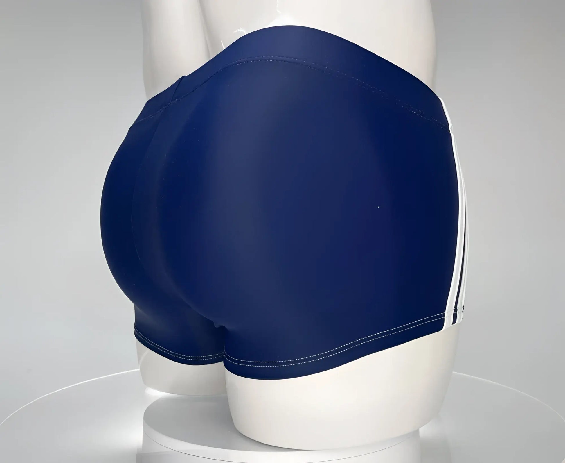 WildmanT navy blue square-cut swim trunks on a mannequin, featuring dual white side stripes and white stitching.