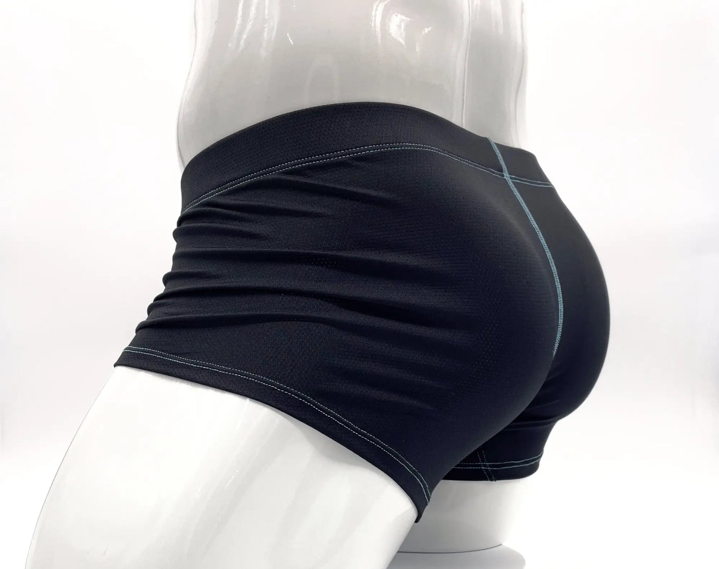 Black boxer briefs with blue contrast stitching on a white mannequin, featuring a textured performance fabric.
