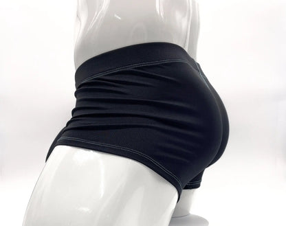 Side view of black, textured boxer briefs with blue stitching on a mannequin.