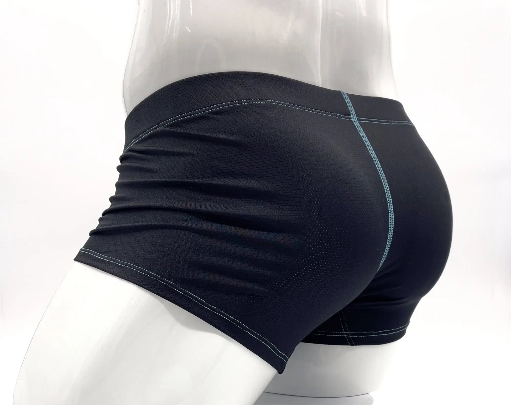 Black boxer briefs with blue contrast stitching on a white mannequin, back view showing textured athletic fabric.