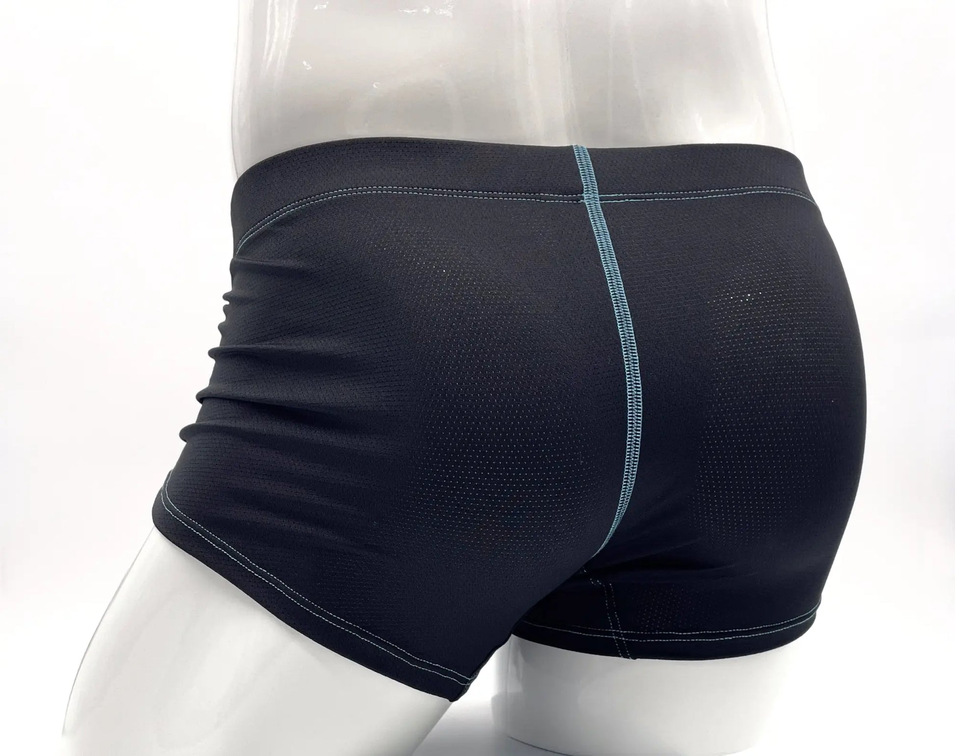 Black perforated boxer briefs on a mannequin with contrasting light blue stitching down the back.