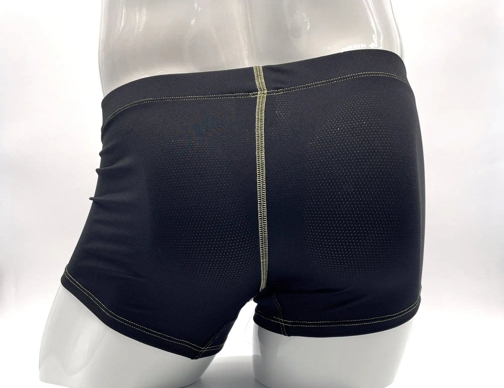 Black mesh boxer briefs with visible yellow stitching, shown from the rear on a mannequin.