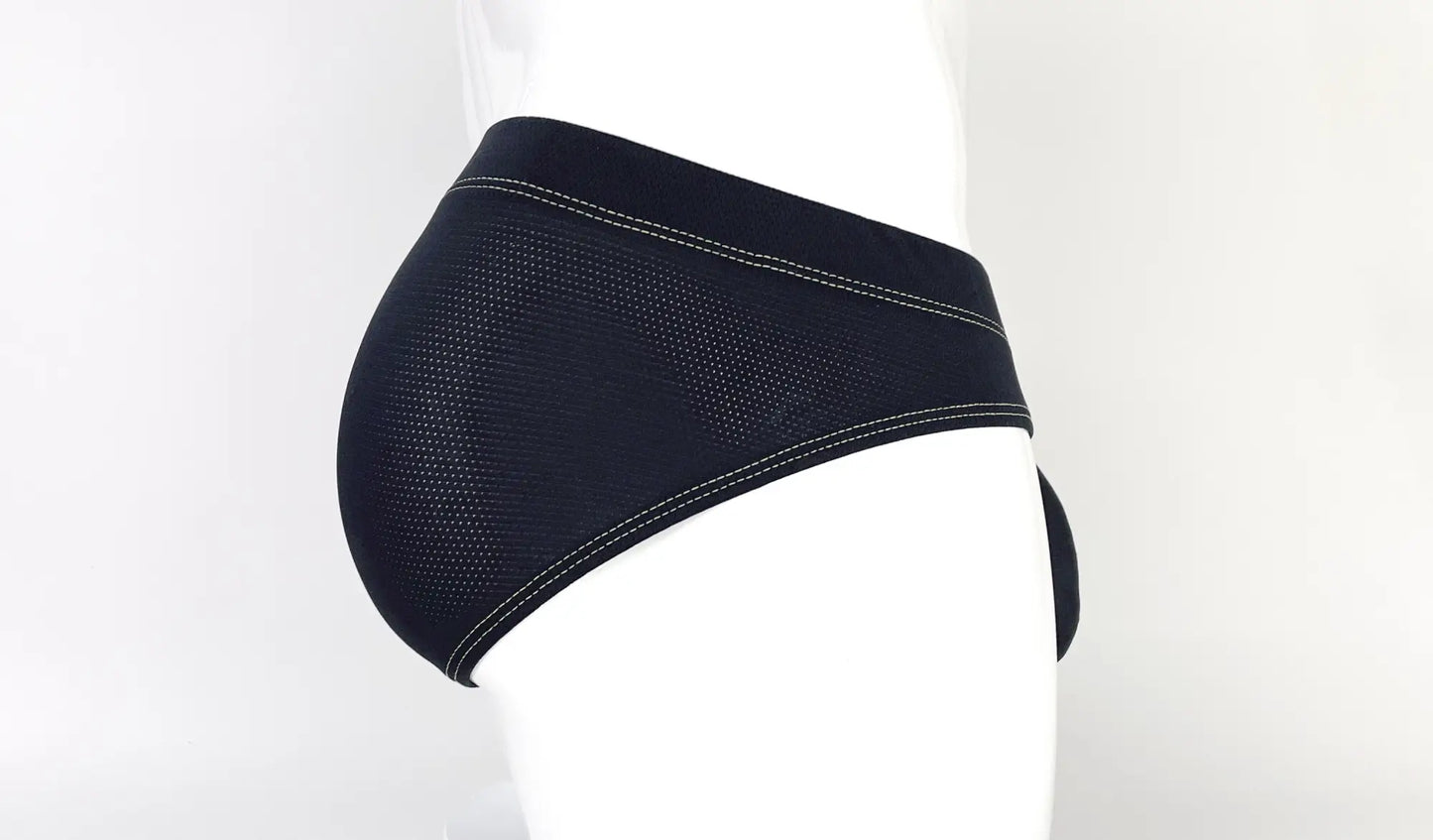 Side view of black, perforated mesh pouch brief featuring contrasting yellow stitching on a mannequin.