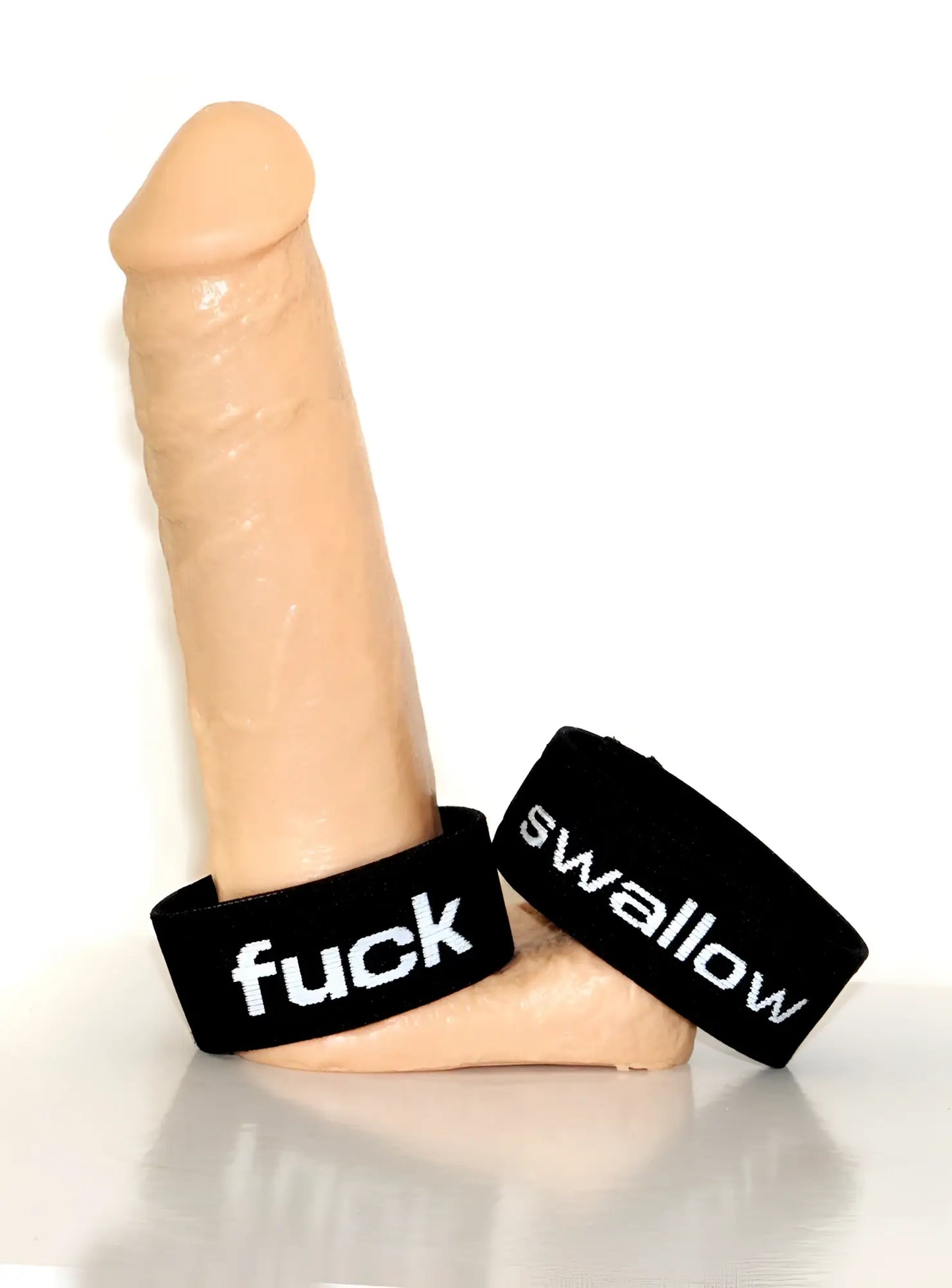 Beige silicone dildo with black wristbands featuring white text fuck and swallow from wildmant verbal max cock ring swallow
