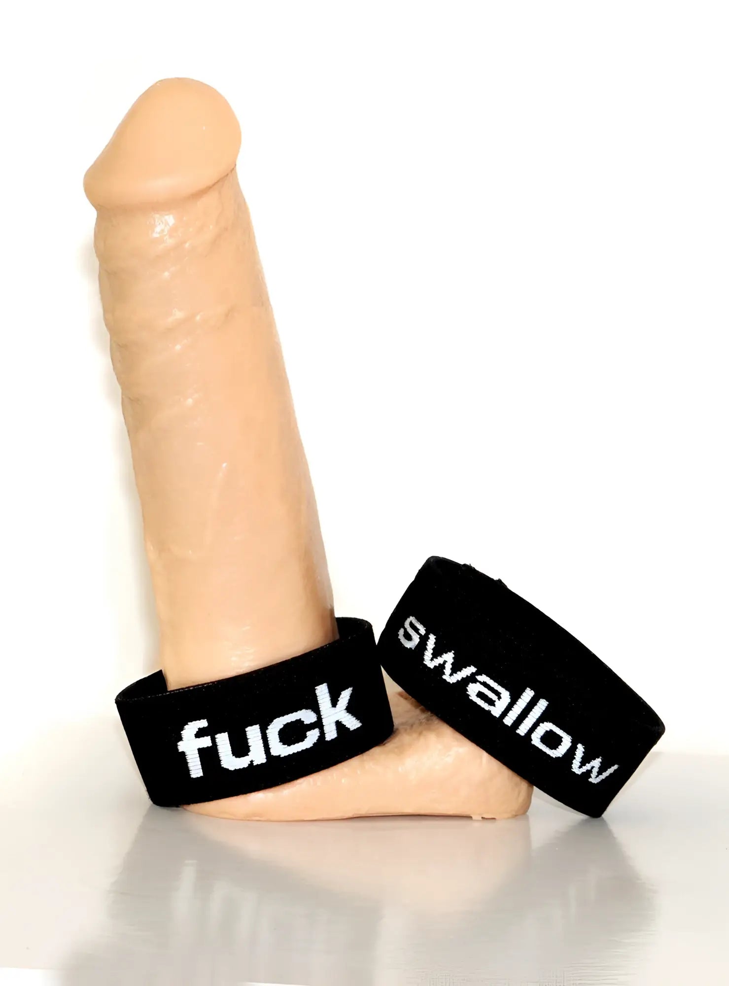 Beige silicone dildo with black wristbands featuring white text fuck and swallow from wildmant verbal max cock ring swallow