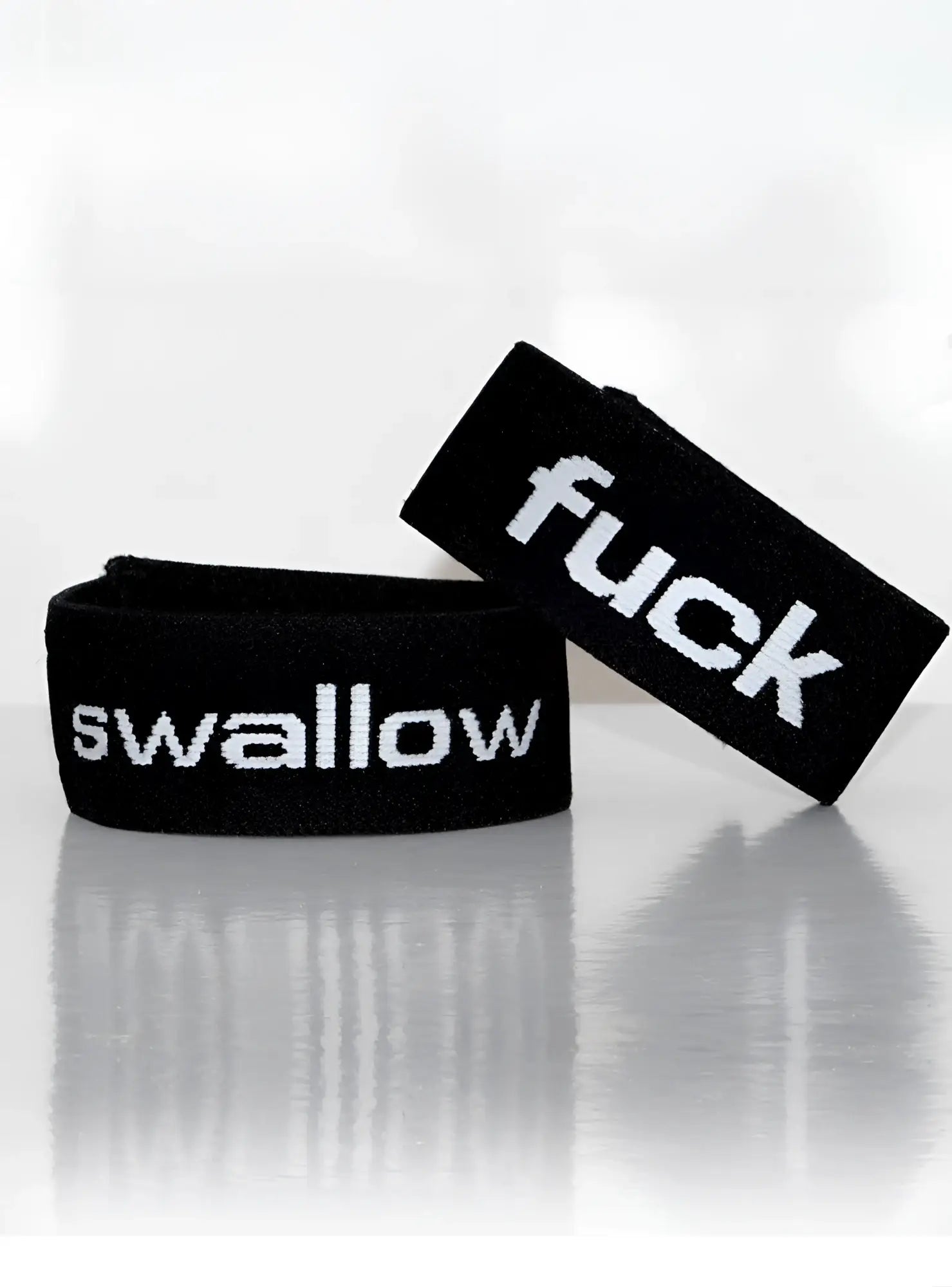 Black elastic wristband with white embroidered text fuck and swallow from wildmant verbal max cock-ring swallow product
