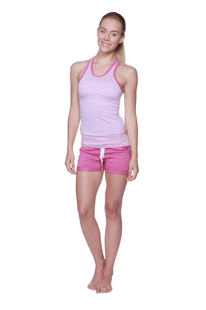 A woman wearing a light pink and white striped halter tank top with matching bright pink women’s performance yoga shorts