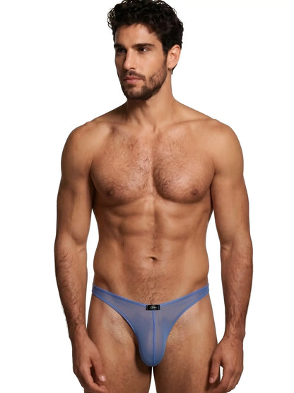 Xtremen blue sheer mesh thong worn by a fit man, featuring a center brand logo tab and minimalist, form-fitting design.