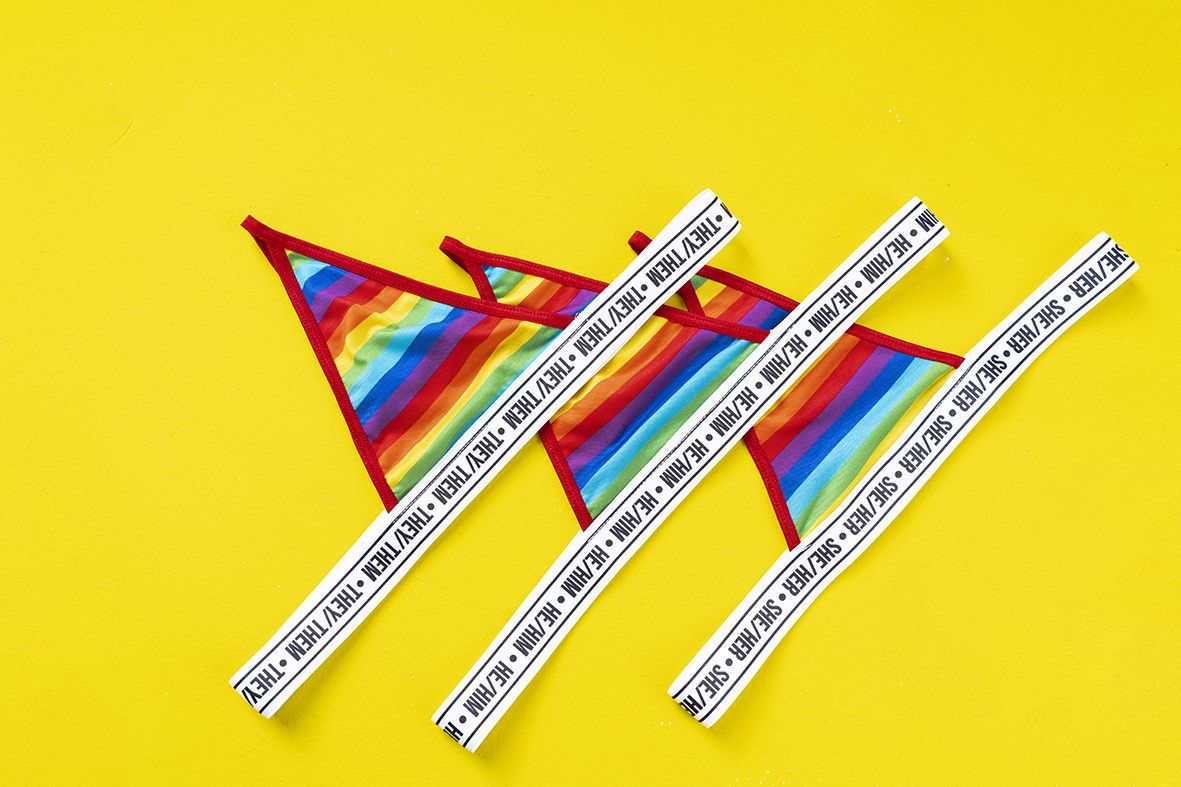 Mapale 123c rainbow thong featuring rainbow stripes red trim and white elastic waistband with repeating they thm text