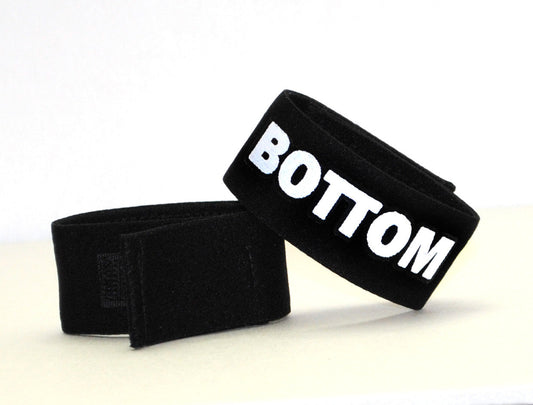 Black velour wristband with bold white bottom lettering from wildmant fetish max cock-ring bottom collection