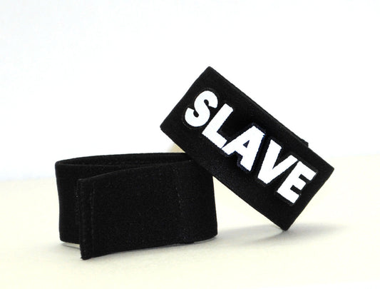 Black velour wristband with bold white embroidered slave lettering from wildmant fetish max cock ring slave product