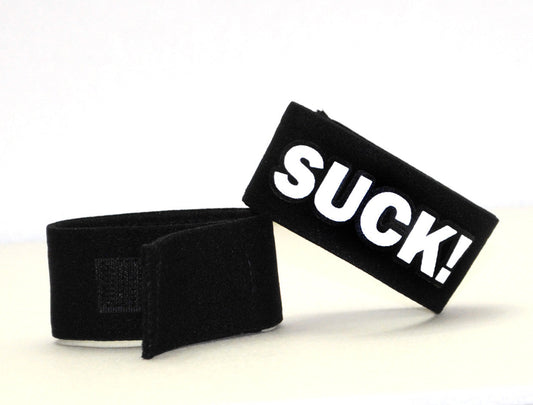 Black velour wristband with bold white suck lettering from wildmant fetish max cock ring suck collection